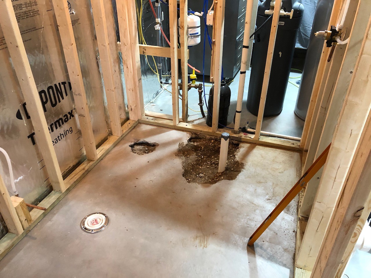 Holes in concrete floor looking for the shower drain