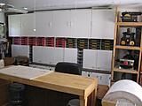 Workshop Oct 2009006
Right Wall back
Red boxes are Screws (6,8,10) 1 1/2" to 3"
Black boxes are bolts (carriage, Hex, Pan, Round, Truss) 1 1/2" to 3" 
Desk & Chair behind movable work bench. 
roll of paper on movable cart.