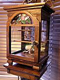 Walnut birdcage for our lovebird.
Front is glass. Top is stained glass.