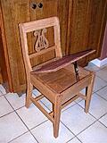 We made two of these chairs.They are regular sized chairs in height. 
the short backs make them appear smaller, and that was the intention. We wanted to be able to sit 6 people at our kitchen table, without it looking crowded. We also wanted storage under the seat. 
The wood is QS white oak. I stained it to look like walnut to match the walnut table and existing chairs. 
Also, I love lyre's, so I designed the back with lyre's. :)